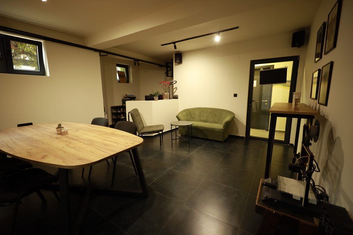 The RABOTEKA meeting room with an oak oval table, green sofa and 3D printer